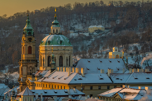 Mala Strana y la iglesia de San Nicolás en el casco antiguo de Praga cubiertas de nieve en la mañana de invierno. photo