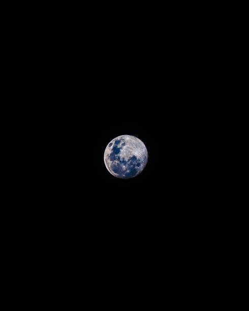 istock Vertical shot of the full moon isolated on a black background 1451366485