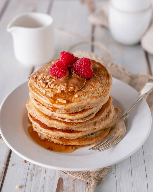 istock Stack of pancakes with raspberries, nuts and syrup 1451366698