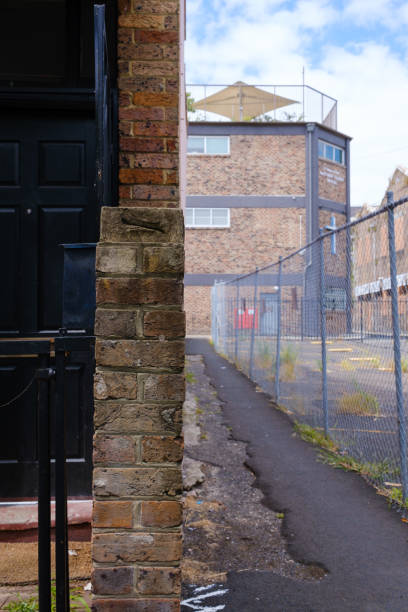 istock Narrow lane between a building and fence 1451369522