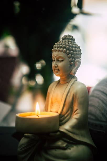 istock Vertical shot of Buddha statue holding a candle 1451370178