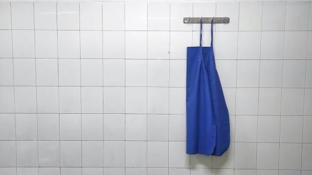 istock Blue clean apron hanged on the white tiled wall 1451373131