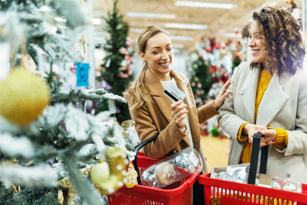 Female friends in a mall shopping for Christmas with credit card