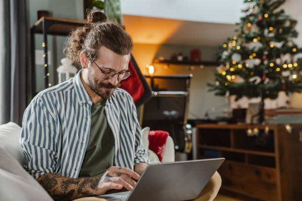 istock Young man using laptop at home during winter holidays 1451374629
