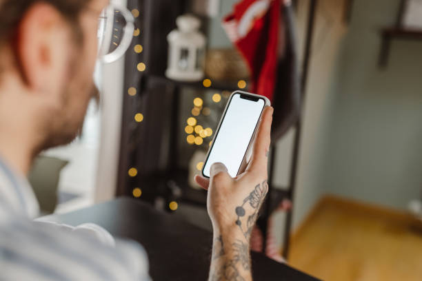istock Young man holding a smart phone with blank screen 1451374645