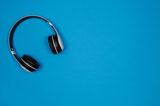 istock White headphones with black earmuffs on a blue background.Top view .Copy space 1451383291