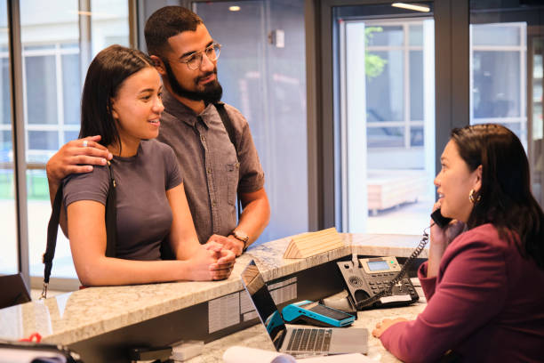 istock Smiling young couple checking in at their hotel during vacation 1451394763