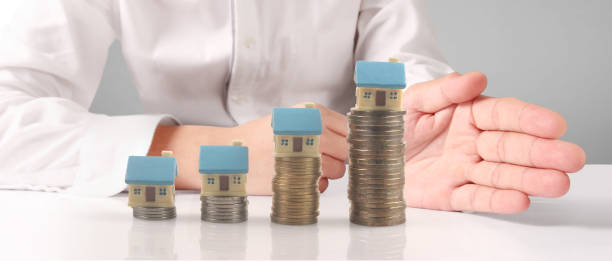 istock House Residential Structure in hand ,model house and coin 1451397288