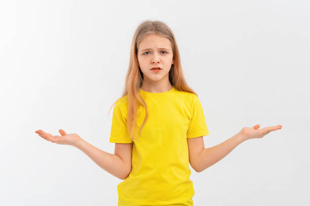 confused teen girl spread palms aside and shrugging shoulders, saying sorry, dont know, have nothing, standing confused against white background - blank expression head and shoulders horizontal studio shot imagens e fotografias de stock