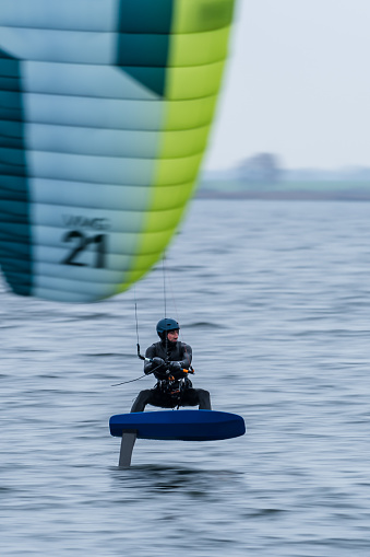 Hydrofoil Race Kitesurfer with kite in the foreground in cold winter conditions