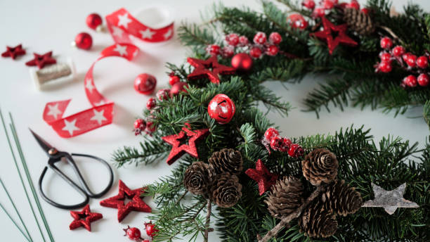 クリスマスリースのドアは、赤いベリー、星、コーン、はさみ、リボンで飾られた自然なクリスマスツリーの枝を白いテーブル、上面図、コピー用スペースにしました。家庭用クリスマスリ�