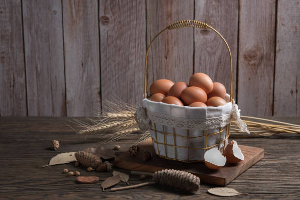 istock Chicken eggs in gift basket on wood table. 1451424677