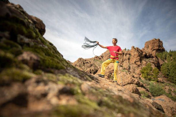 Lifestyle image of a middle age man organizing his ropes after a day out climbing