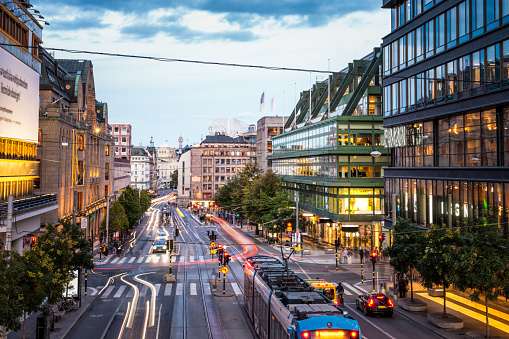 A long exposure looking down one of Stockholm's busiest shopping and central travel streets after sunset, with light trails from the lights of moving vehicles.