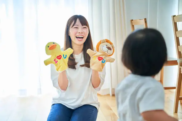 Photo of Parent and child playing with puppets