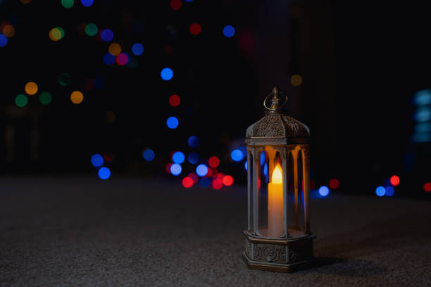 istock Islamic Lantern lighting up with blurry bokeh light background.Eid decorative traditional Arabic lamps illuminated ready for the Holy season of Ramadan Kareem.Islamic muslim holidays celebrate concept 1451434202