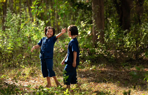 In rural Thailand, little girls play together joyfully laugh together