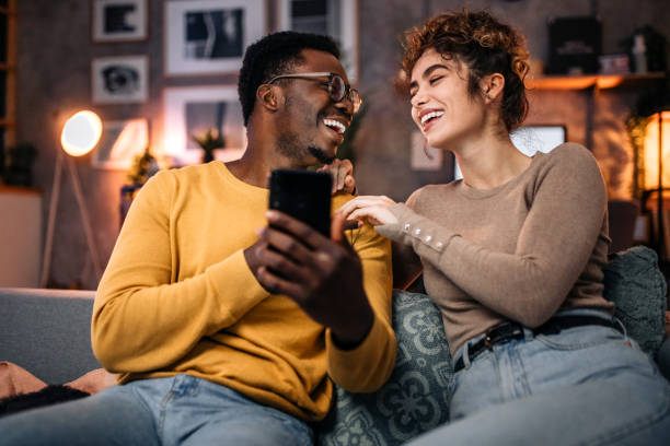 istock Young couple at home in the evening, having fun using smart phone 1451439308