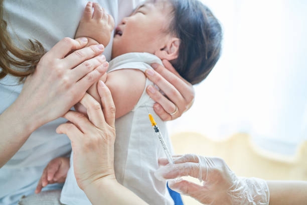 istock Infants being held by their mothers and receiving vaccinations 1451440181