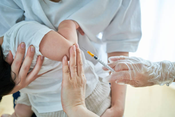 istock Infants being held by their mothers and receiving vaccinations 1451440283