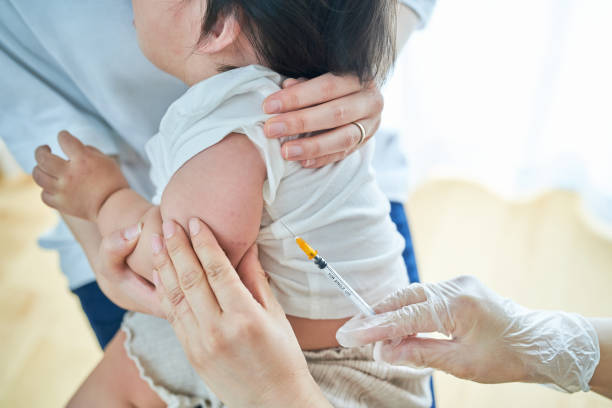istock Infants being held by their mothers and receiving vaccinations 1451440368