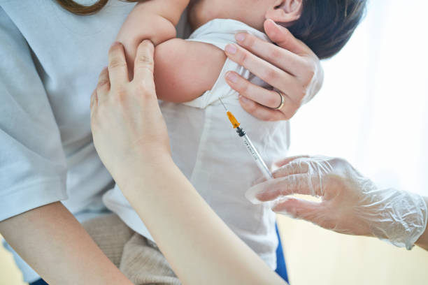 istock Infants being held by their mothers and receiving vaccinations 1451440500