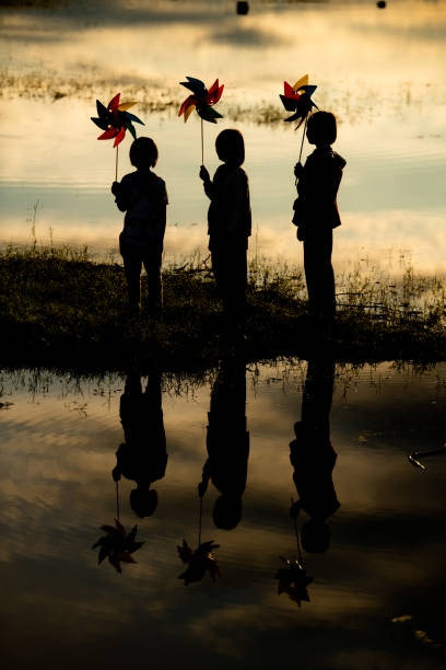 niños montando en bicicleta y corriendo a primera luz del día mientras brilla el sol - run of the mill fotografías e imágenes de stock