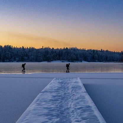 Ice skating on a frozen lake at sunset in Stockholm