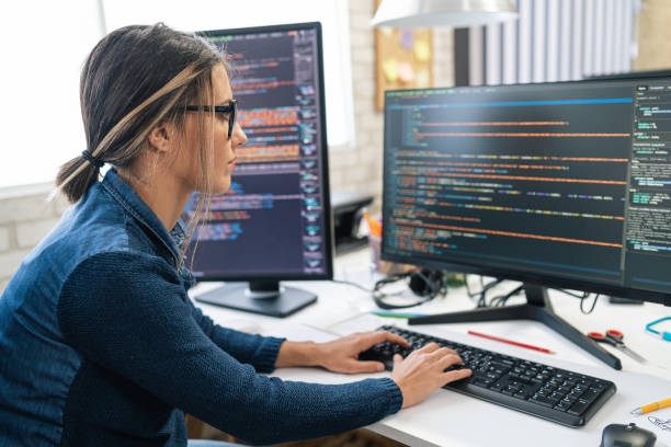 sviluppatore freelance femminile di codifica e programmazione. codifica su due con schermate con linguaggio di codice e applicazione. - programmatore di computer foto e immagini stock