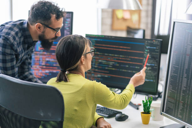 Software programmers analyzing html code and database, brainstorming script ideas to develop new security system. Engineers working with coding language collaborating on group project. stock photo