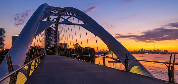 A panoramic view of the Humber Bay Arch Bridge in Toronto, Canada during a mesmerizing sunset
