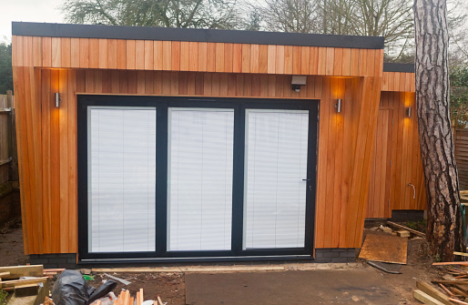 Western Red Cedar, tongue and groove wood-clad Home Garden Office and Studio with bifold doors that open on to a terrace, nears completion.