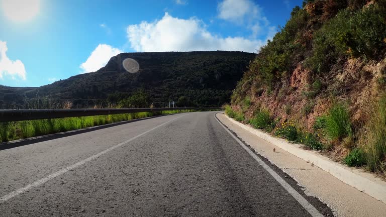 Cyclist riding bicycle uphill in mountains, POV shot. Cycling and triathlon