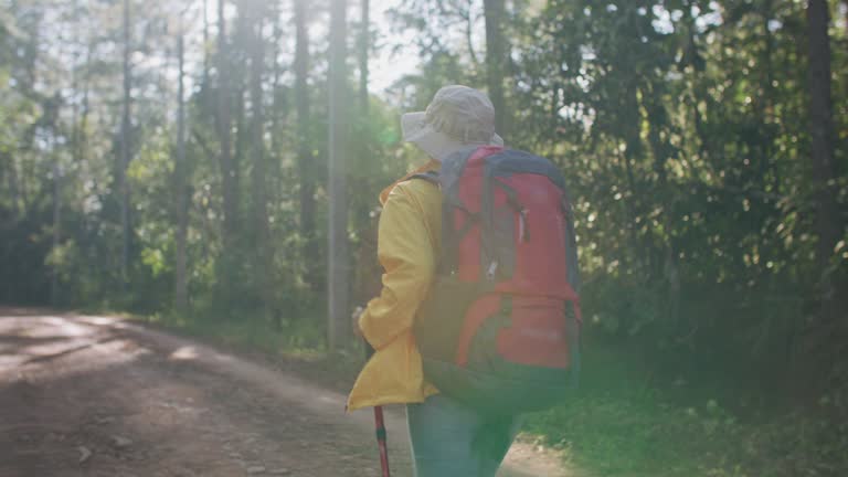 Woman hiker in yellow raincoat with backpack