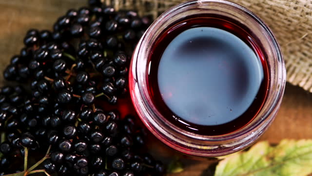 Top view close-up Black elderberry on vintage boards and sacks, elderberry juice. Black berry with squeezed juice