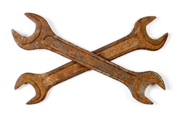 Photo of Two crossed wrenches on a white background.