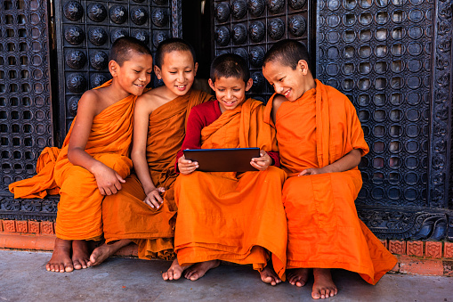 Novice Buddhist monks using digital tablet in the monastery in Bhaktapur, Nepal