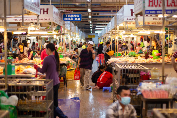 un uomo cammina attraverso il mercato mattutino - central dalat, vietnam - for sale industry farmers market market stall foto e immagini stock
