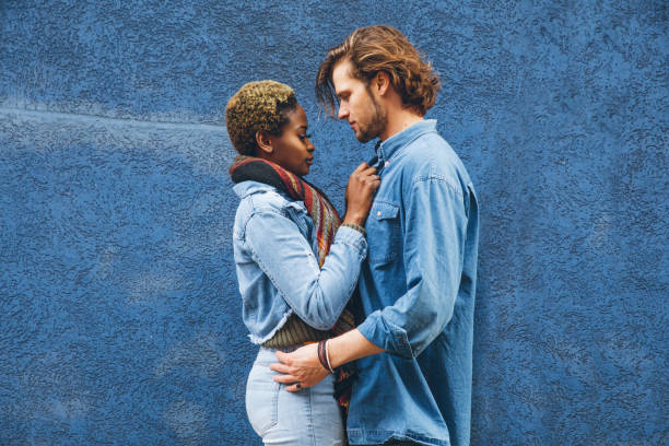 istock Couple embracing agains a blue wall 1451480394