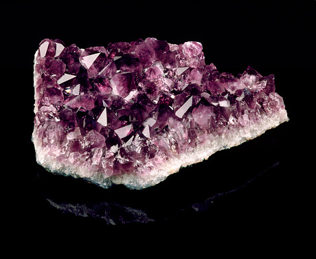 Amethyst crystal isolated on the black background.