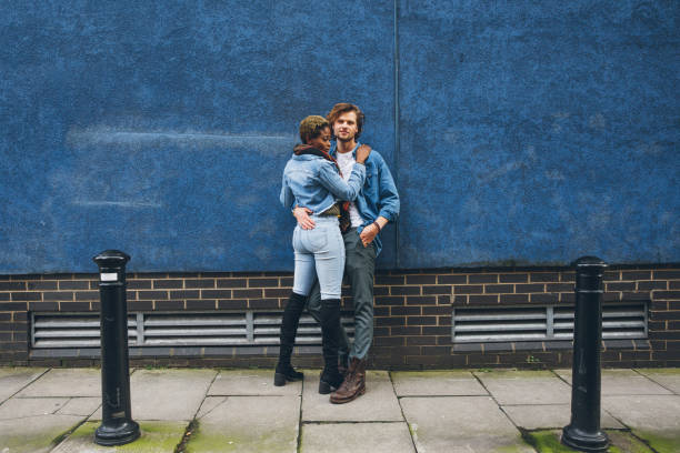 istock Couple embracing agains a blue wall 1451486263