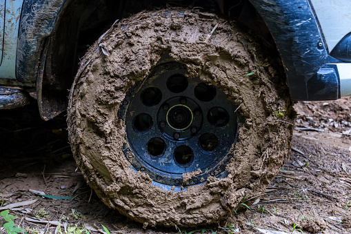 Tire has been mired in the mud. Wheel closeup  with a muddy. Wheel of tire is dirty because mud