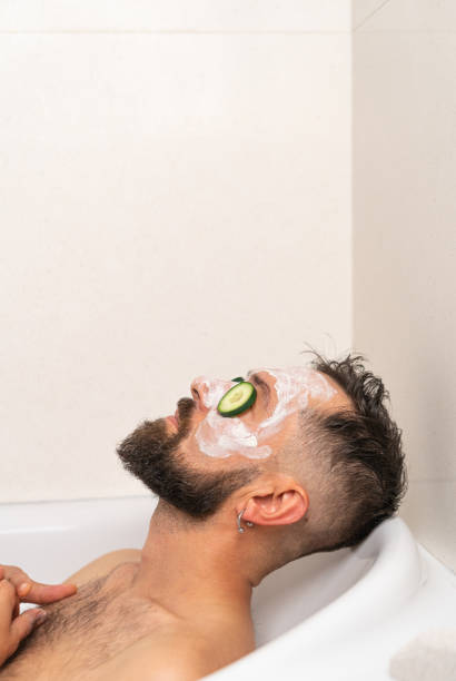 istock man with cucumber and face mask relaxing in bath at home 1451489353