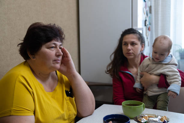 istock The woman experiences a headache while drinking tea with her family. 1451491191