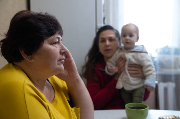 istock The woman experiences a headache while drinking tea with her family. 1451491201