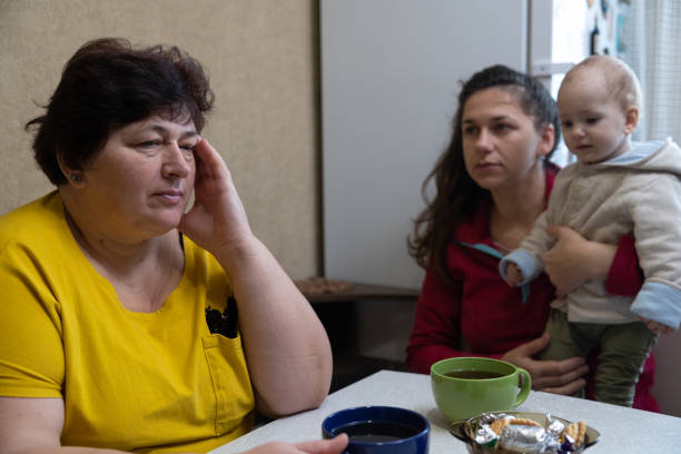 istock The woman experiences a headache while drinking tea with her family. 1451491204