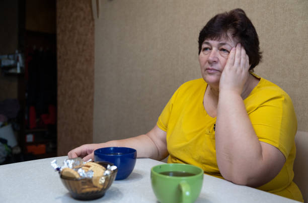istock The woman has a headache while having lunch in the kitchen. 1451491240