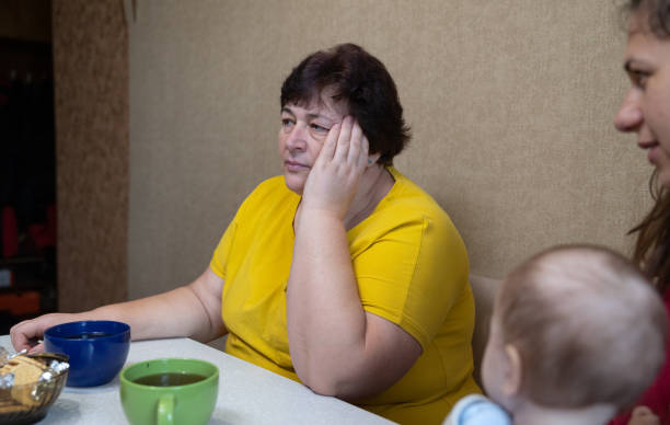 istock The woman experiences a headache while drinking tea with her family. 1451491241