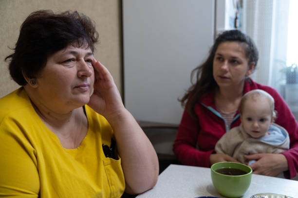 istock The woman experiences a headache while drinking tea with her family. 1451491248