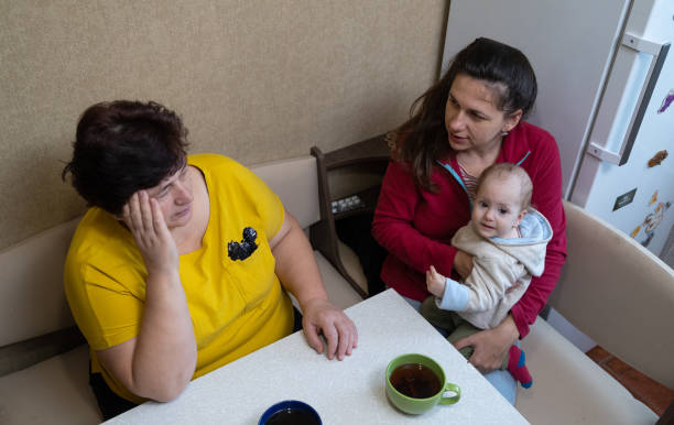 istock The woman experiences a headache while drinking tea with her family. 1451491279